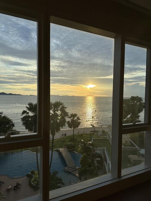 A stunning seaside view from the apartment with a visible swimming pool.