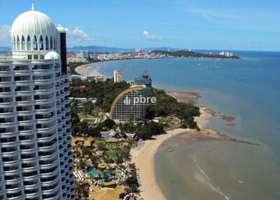 Aerial view of beachfront high-rise building with city and sea in the background