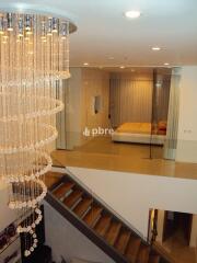 Modern bedroom with chandelier and staircase view