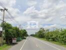 Road with greenery on both sides and electric poles